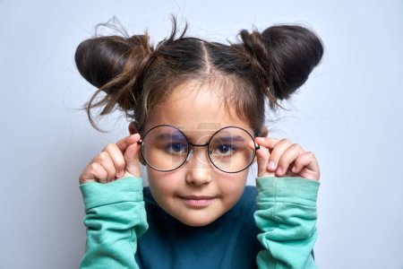 Photo for Caucasian little girl wearing glasses squinting while looking at camera isolated on white background. Vision problems concept - Royalty Free Image