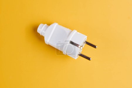 Photo for Electric European white plug for socket isolated on yellow background - Royalty Free Image