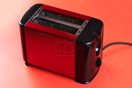 Foto de Moderna tostadora de cocina nueva para pan y sándwiches aislados sobre fondo rojo - Imagen libre de derechos
