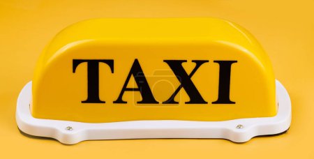 Téléchargez les photos : Panneau de taxi jaune pour toit de voiture isolé sur fond jaune - en image libre de droit