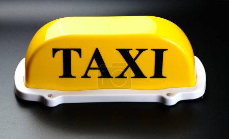 Téléchargez les photos : Panneau de taxi jaune pour toit de voiture isolé sur fond noir - en image libre de droit