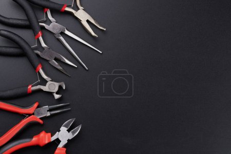 Photo for Set of different types of pliers and side cutters isolated on black background. Hand tools for repair, construction and maintenance - Royalty Free Image