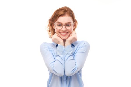 Photo for Portrait of attractive red-haired girl in business shirt and glasses smiling joyfully isolated on white studio backgroun - Royalty Free Image