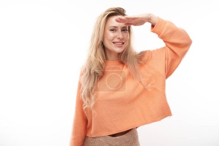Photo for Young blonde woman in casual looks future, looking far away distance with hand over head isolated on white background. Search concept. - Royalty Free Image