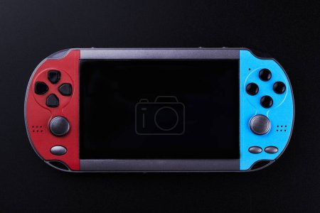 Photo for Hybrid handheld portable video game console with switch detachable controllers on both sides isolated on black background, wireless gadget - Royalty Free Image