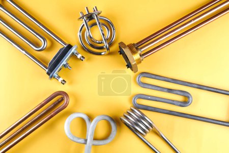 Photo for Set of different types Tubular electric Heating elements made of steel for washing machines, boiling water, heating, isolated on yellow background - Royalty Free Image