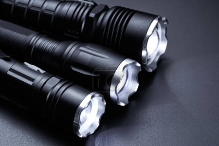 Foto de Set de linternas tácticas de bolsillo negro aisladas sobre fondo negro - Imagen libre de derechos