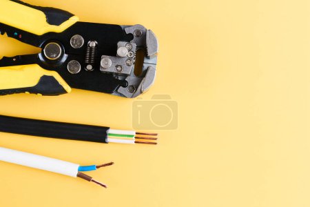 Téléchargez les photos : Outil de dénudage et de sertissage des câbles, Décapants isolés sur fond jaune - en image libre de droit