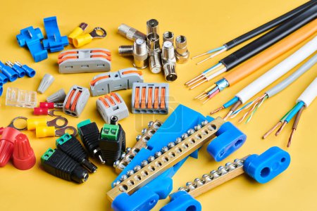 Photo for Different electrical tools isolated on yellow background, electrician equipment, wires, terminals, connectors, fuses, switches - Royalty Free Image