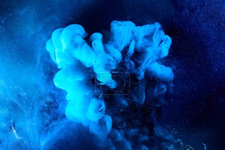 Foto de Blue abstract ocean background. Splashes and waves of paint under water, clouds of smoke in motion. - Imagen libre de derechos