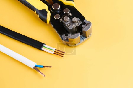 Téléchargez les photos : Outil de dénudage et de sertissage des câbles, Décapants isolés sur fond jaune - en image libre de droit