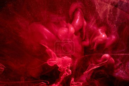 Téléchargez les photos : Red abstract ocean background. Splashes and waves of paint under water, clouds of smoke in motion. - en image libre de droit