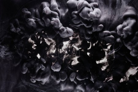Téléchargez les photos : Black dark abstract ocean background. Splashes and waves of paint under water, clouds of interstellar smoke in motion - en image libre de droit