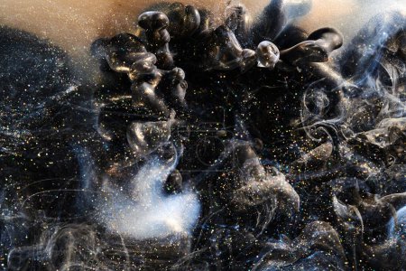 Téléchargez les photos : Black gold abstract ocean background. Splashes and waves of sparkling paint under water, clouds of interstellar smoke in motion - en image libre de droit