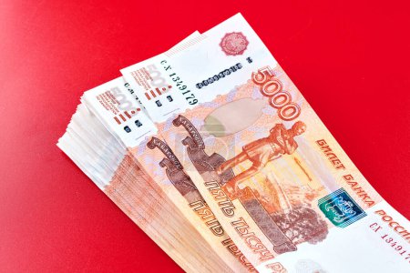 Foto de Rublos rusos cinco mil billetes, pila de dinero sobre fondo rojo - Imagen libre de derechos