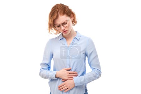 Photo for Portrait of young woman holding hands on stomach, suffering from menstruation pain and intestines discomfort isolated on white background - Royalty Free Image