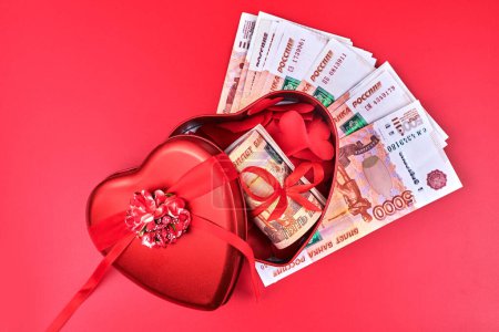 Téléchargez les photos : Roubles russes sur fond rouge, paquet de cinq mille billets avec ruban rouge dans la boîte du cœur, concept de cadeau d'argent - en image libre de droit