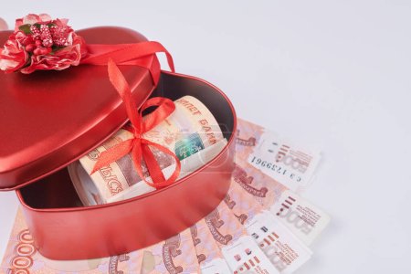 Téléchargez les photos : Roubles russes sur fond blanc, paquet de cinq mille billets avec ruban rouge dans la boîte du cœur, concept de cadeau d'argent - en image libre de droit