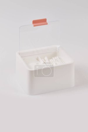 Téléchargez les photos : Organisateur plastique blanc neuf pour produits cosmétiques rempli de bâtons et tampons de coton isolés sur fond blanc - en image libre de droit