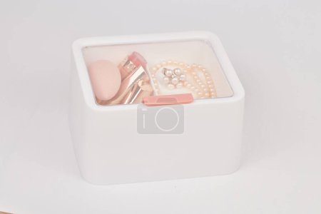 Téléchargez les photos : Organisateur plastique blanc neuf pour cosmétiques rempli de produits de maquillage et d'accessoires isolés sur fond blanc - en image libre de droit