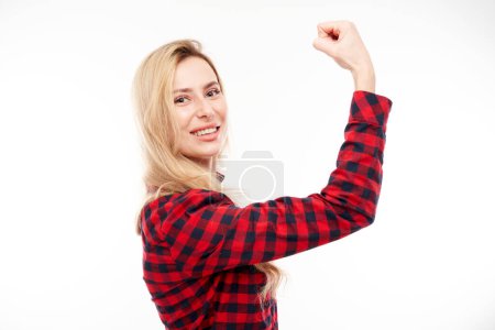 Téléchargez les photos : Portrait de jeune femme blonde sexy montrant biceps, démontrant la puissance de la fille isolée sur fond blanc - en image libre de droit
