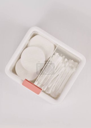 Photo for White new plastic organizer for cosmetic products filled with cotton sticks and pads isolated on white background - Royalty Free Image