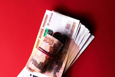 Foto de Rublos rusos cinco mil billetes, paquete de dinero con cinta roja sobre fondo rojo, concepto de regalo - Imagen libre de derechos
