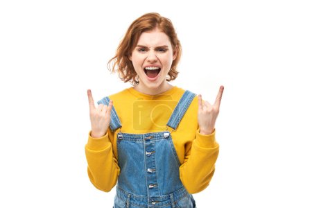 Foto de Retrato de una joven pelirroja mostrando un gesto de rock and roll con dedos aislados sobre fondo blanco - Imagen libre de derechos