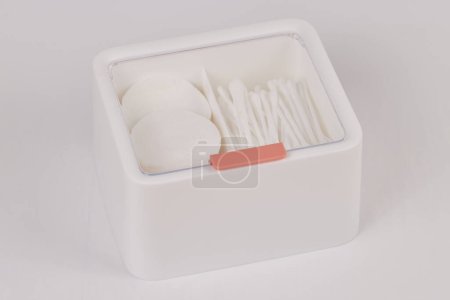 Photo for White new plastic organizer for cosmetic products filled with cotton sticks and pads isolated on white background - Royalty Free Image