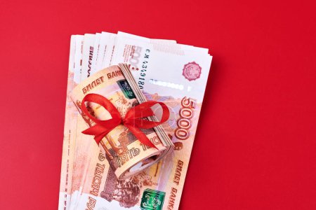 Photo for Russian rubles five thousand banknotes, bundle of money with red ribbon on red background, gift concept - Royalty Free Image