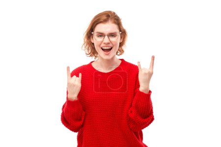 Photo for Portrait of young redhead woman showing rock and roll gesture with fingers isolated on white background - Royalty Free Image
