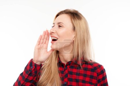 Photo for Portrait of blond young woman screaming into her palms on white studio background. Important information, news concep - Royalty Free Image