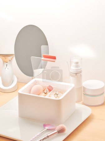 Foto de Organizador plástico blanco para productos cosméticos, maquillaje y accesorios, interior de la sala de belleza - Imagen libre de derechos