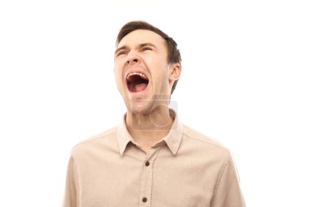 Foto de Retrato enojado morena joven macho gritando aislado en blanco estudio fondo, mostrando emociones negativas - Imagen libre de derechos