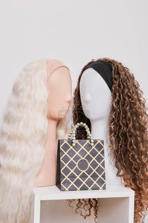 Foto de Escaparate de pelucas de aspecto natural en cabezas de maniquí femenino en salón de belleza, pelo en estante en tienda de pelucas - Imagen libre de derechos