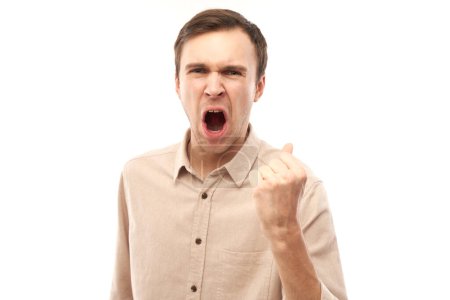 Foto de Retrato enojado morena joven macho gritando aislado en blanco estudio fondo, mostrando emociones negativas - Imagen libre de derechos