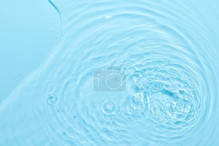 Foto de Fondo abstracto de superficie azul agua. Ondas y ondas de crema hidratante cosmética con burbujas - Imagen libre de derechos
