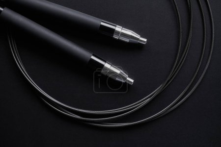 Photo for Black fitness skipping rope close-up on black background. Crossfit sports equipment - Royalty Free Image