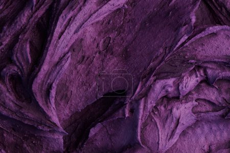 Foto de Fondo decorativo de masilla púrpura. Textura de pared con pasta de relleno aplicada con espátula, guiones caóticos y trazos sobre yeso. Diseño creativo, patrón de piedra, cemen - Imagen libre de derechos