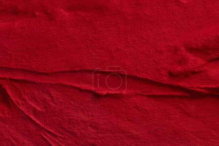 Téléchargez les photos : Décoratif fond de mastic rouge. Texture murale avec de la pâte de remplissage appliquée avec une spatule, des tirets chaotiques et des traits sur du plâtre. Conception créative, motif en pierre, hommes - en image libre de droit