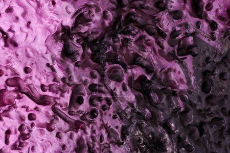 Téléchargez les photos : Décoratif fond de mastic violet. Texture murale avec de la pâte de remplissage appliquée avec une spatule, des tirets chaotiques et des traits sur du plâtre. Conception créative, motif en pierre, hommes - en image libre de droit