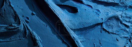 Photo for Decorative blue putty background. Wall texture with filler paste applied with spatula, chaotic dashes and strokes over plaster. Creative design, stone pattern, cemen - Royalty Free Image