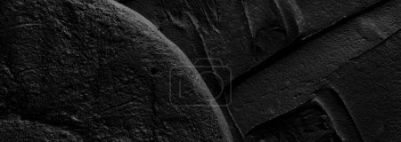 Foto de Fondo decorativo de masilla negra. Textura de pared con pasta de relleno aplicada con espátula, guiones caóticos y trazos sobre yeso. Diseño creativo, patrón de piedra, cemento - Imagen libre de derechos