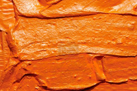 Photo for Decorative orange putty background. Wall texture with filler paste applied with spatula, chaotic dashes and strokes over plaster. Creative design, stone pattern, cemen - Royalty Free Image