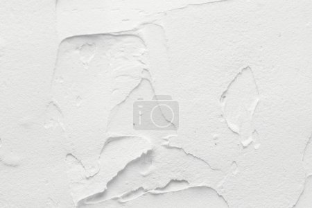 Decorative white putty background. Wall texture with filler paste applied with spatula, chaotic dashes and strokes over plaste