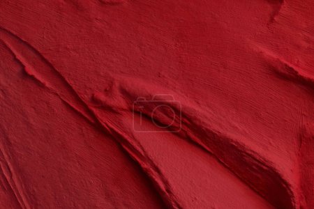 Photo for Decorative red putty background. Wall texture with filler paste applied with spatula, chaotic dashes and strokes over plaster. Creative design, stone pattern, cemen - Royalty Free Image