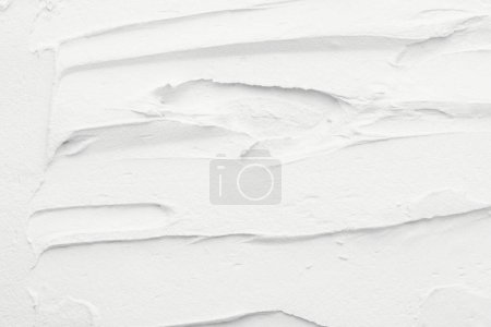 Foto de Fondo decorativo de masilla blanca. Textura de pared con pasta de relleno aplicada con espátula, guiones caóticos y trazos sobre yeso - Imagen libre de derechos