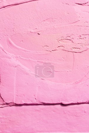 Foto de Fondo decorativo de masilla rosa. Textura de pared con pasta de relleno aplicada con espátula, guiones caóticos y trazos sobre yeso. Diseño creativo, patrón de piedra, cemen - Imagen libre de derechos