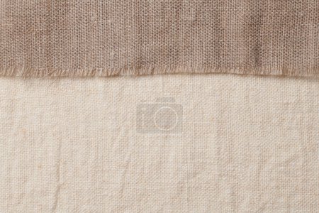 Foto de Ropa de cama en diferentes texturas y colores. Tejidos naturales de lino orgánico y algodón, textiles hechos a mano. Arpillera y lienzo para fondo eco, rústico, boho, hygge - Imagen libre de derechos