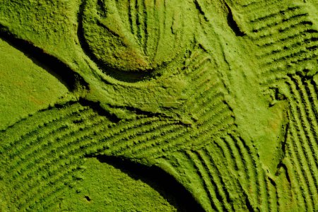Téléchargez les photos : Décoratif fond de mastic vert. Texture murale avec de la pâte de remplissage appliquée avec une spatule, des tirets chaotiques et des traits sur du plâtre. Conception créative, motif en pierre, hommes - en image libre de droit